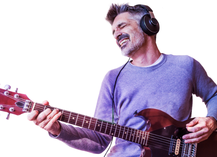 Man wearing headphones while playing the guitar with a blue background.