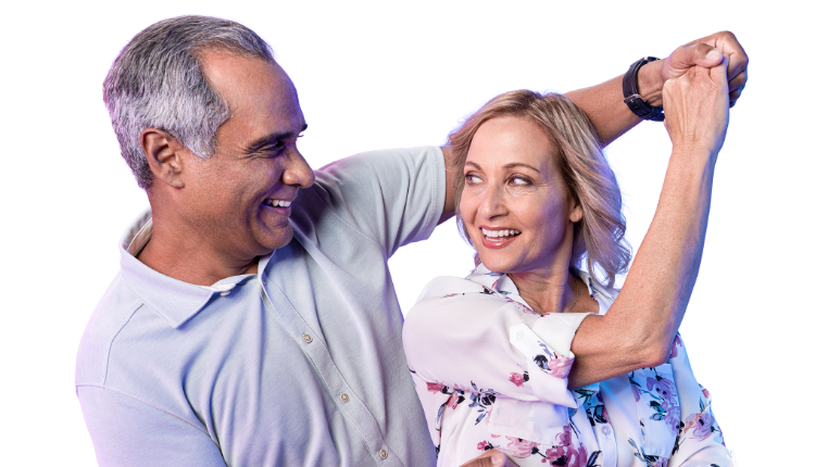 An elderly man and woman dancing and looking at each other with a blue background.