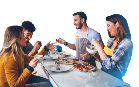 happy young men and women gathered around a table while eating food