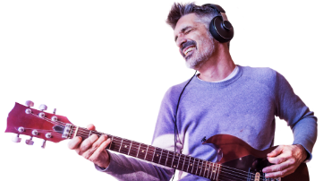 man wearing headphones while playing the guitar